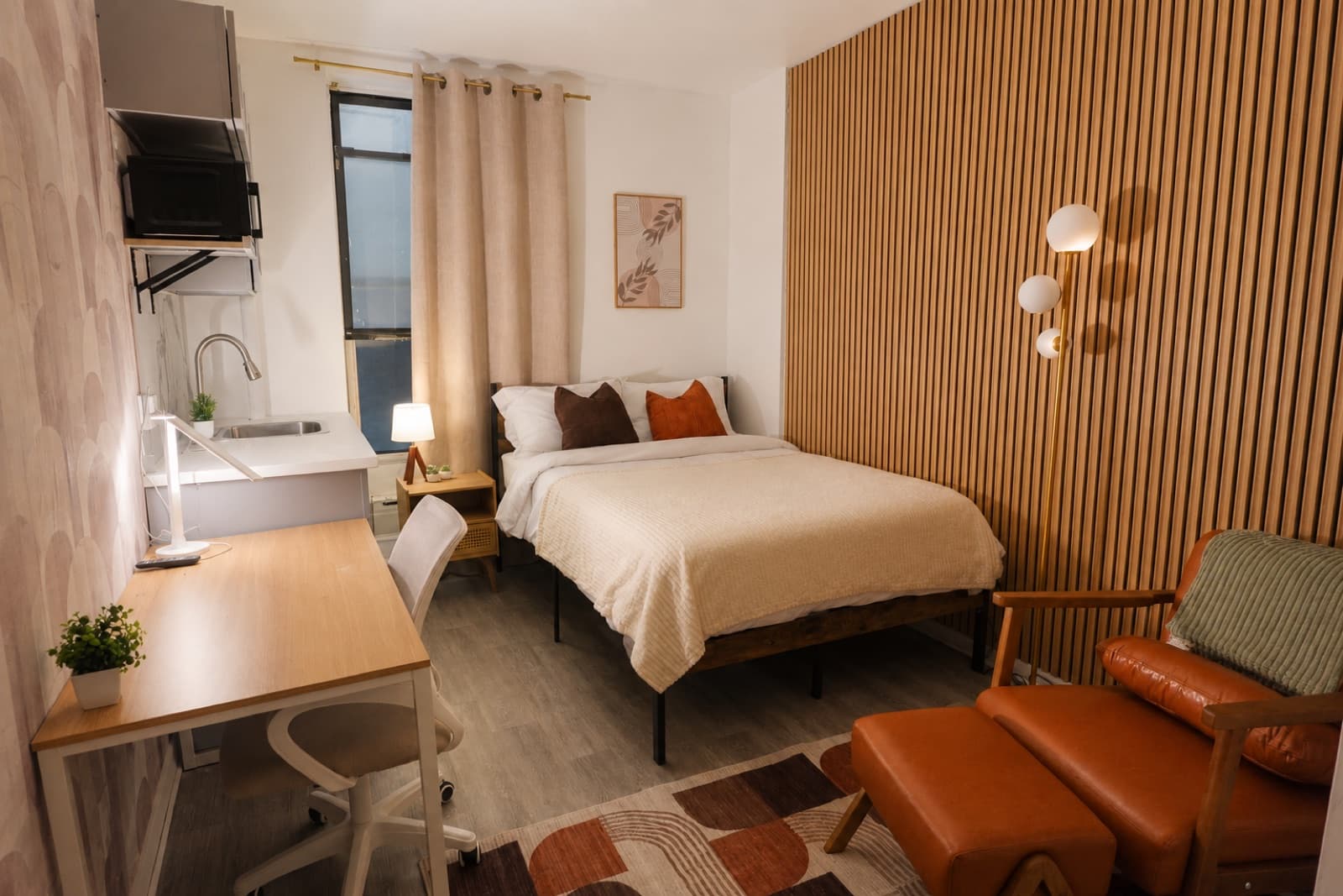 Furnished studio with ensuite bathroom at Amsterdam Place, Upper West Side NYC — full studio with bed, desk, and oak slat accent wall