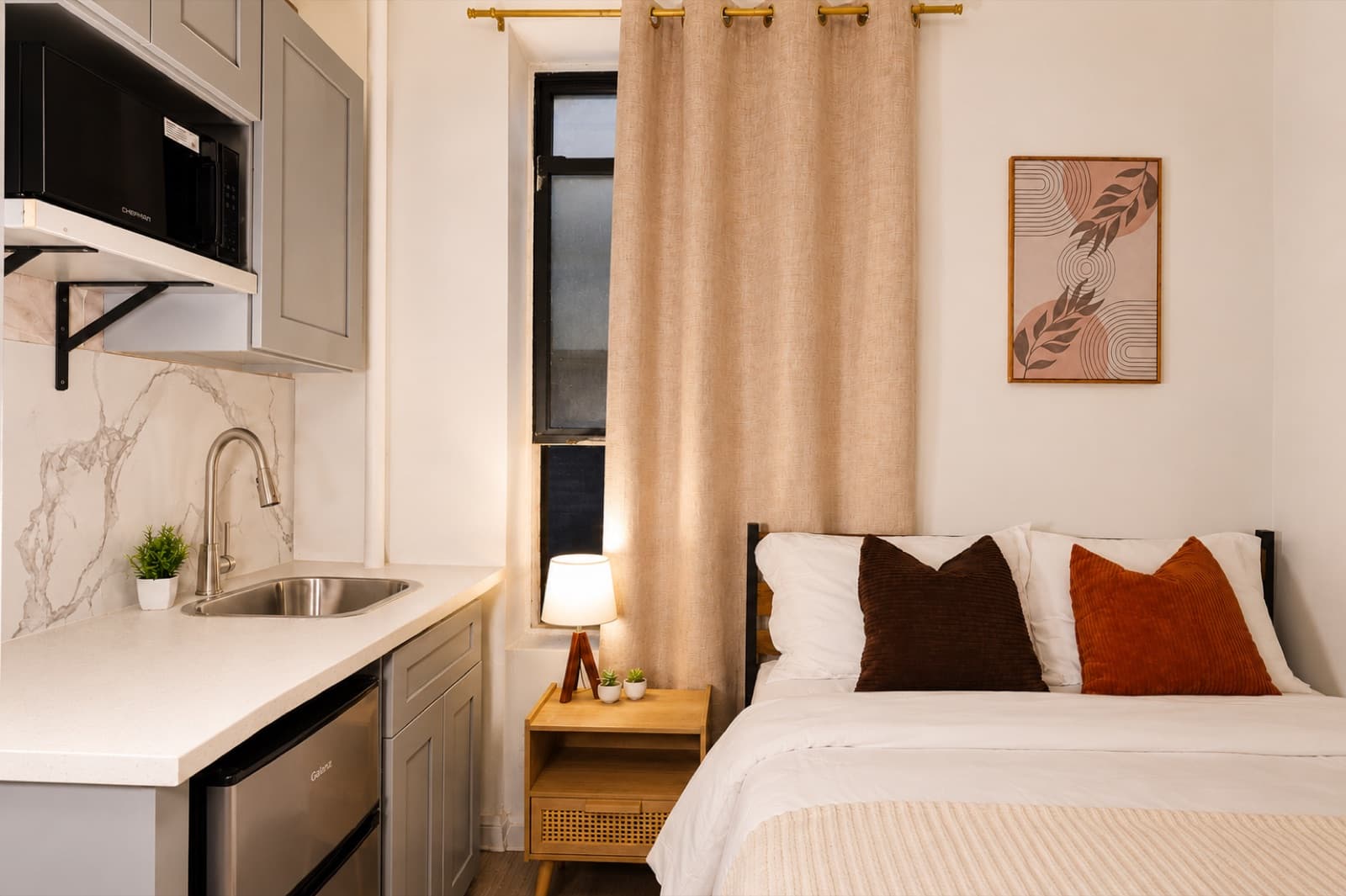Furnished studio with ensuite bathroom at Amsterdam Place, Upper West Side NYC — kitchenette and bed with a marble backsplash