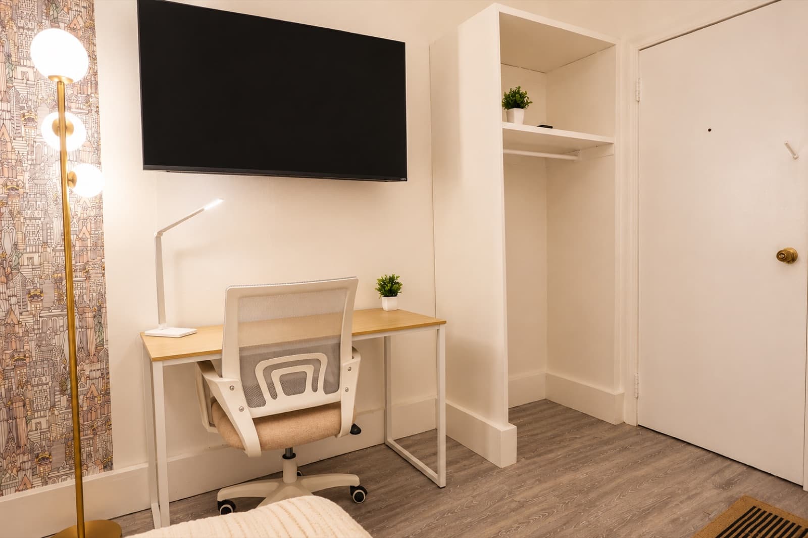 Private furnished room at Amsterdam Place, Upper West Side NYC — workspace with an open closet and wall-mounted TV