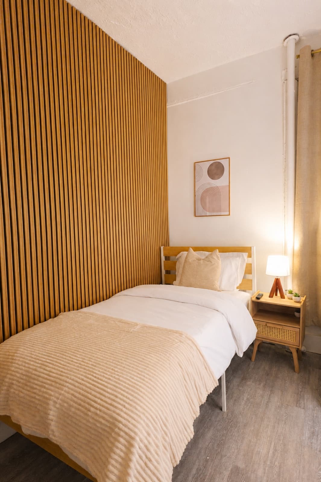 Private furnished room at Amsterdam Place, Upper West Side NYC — twin bed against the oak slat accent wall